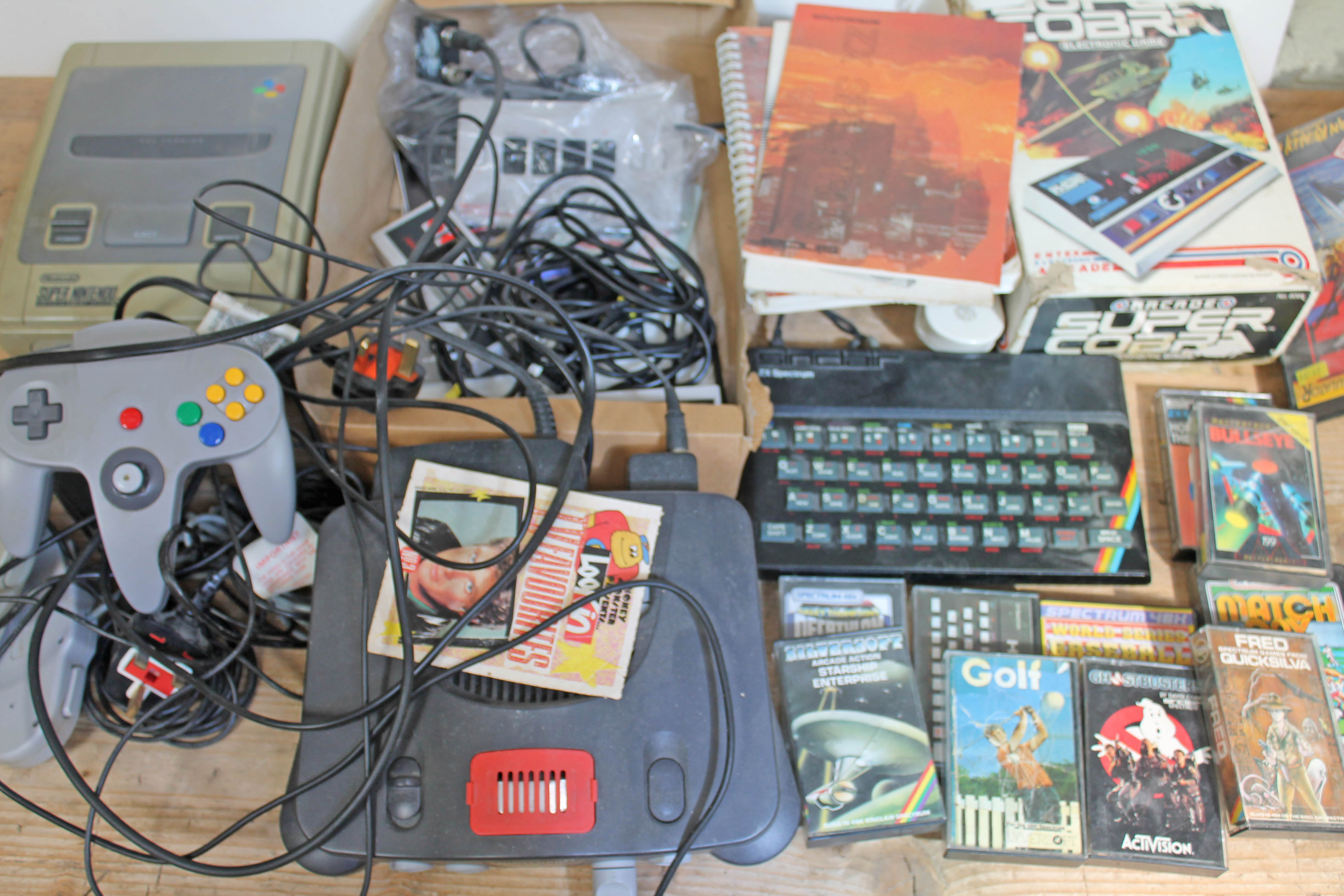 A quantity of vintage games consoles including Nintendo, Spectrum etc. various accessories and