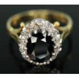 A diamond and sapphire cluster ring, the central dark blue oval cut sapphire weighing approx. 2.00