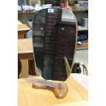 A retro shield shape mirror on wooden kidney shaped base.