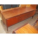 A teak sideboard by Heals, three central drawers with brass ring pull knobs and two cupboards either