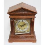 An architectural oak mantle clock, brass and silvered dial, movement striking on two gongs, height