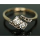 An early 20th century diamond cross over ring, the two central round brilliant cut diamonds weighing