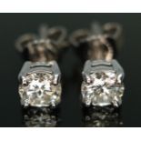 A pair of diamond solitaire stud earrings, each four claw set modern round brilliant cut diamond