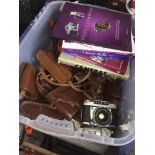 A box of various cameras to include old and camera books.