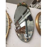 Oval bevelled mirror with applied flowers