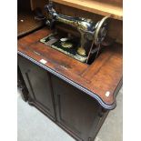 A Singer treadle sewing machine in mahogany cabinet.