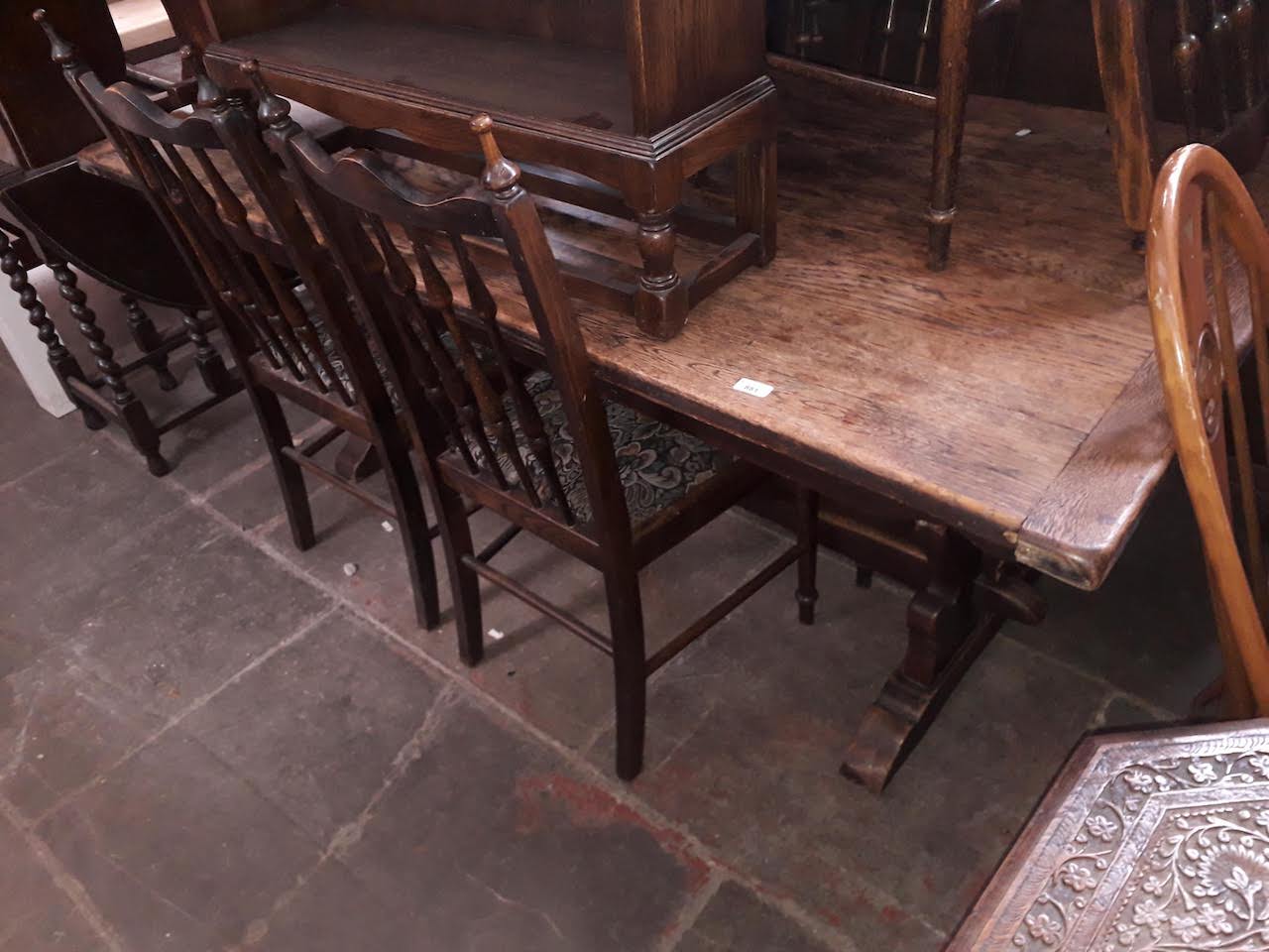 A large oak two plank and cleated end refectory table together with eight spindle back chairs