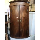 A Georgian mahogany bow front corner cabinet