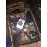 A box with binoculars, vinyl singles, cameras, etc.