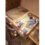 A leather case of collectors cards, book of badges and a world stamp album.