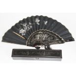 A Chinese black lacquer polychrome decorated fan with box.