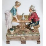 A large Austrian/German pottery figure group modelled as a man and woman at a table, height 54cm.