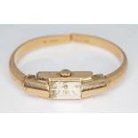 A vintage hallmarked 9ct gold Olma ladies manual wind bangle wristwatch, the inside case back and