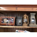 Three storm lamps and a cased Barometer, stamped 'Barometre Holostreique', HPBN.