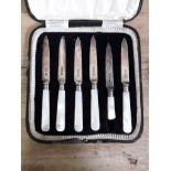 A cased set of six hallmarked silver bladed knives with mother of pearl handles, (one handle