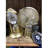 Five quartz clocks including two revolving pendulum clocks under glass domes.