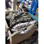 A box of military issue camouflage items including two ruck sacks, ruck covers, cotton hats.