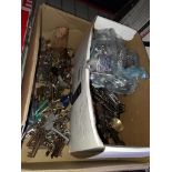 A box containing old keys, modern door fixings and brass door furniture