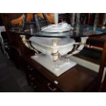 A reproduction Grecian style coffee table with oval glass top.