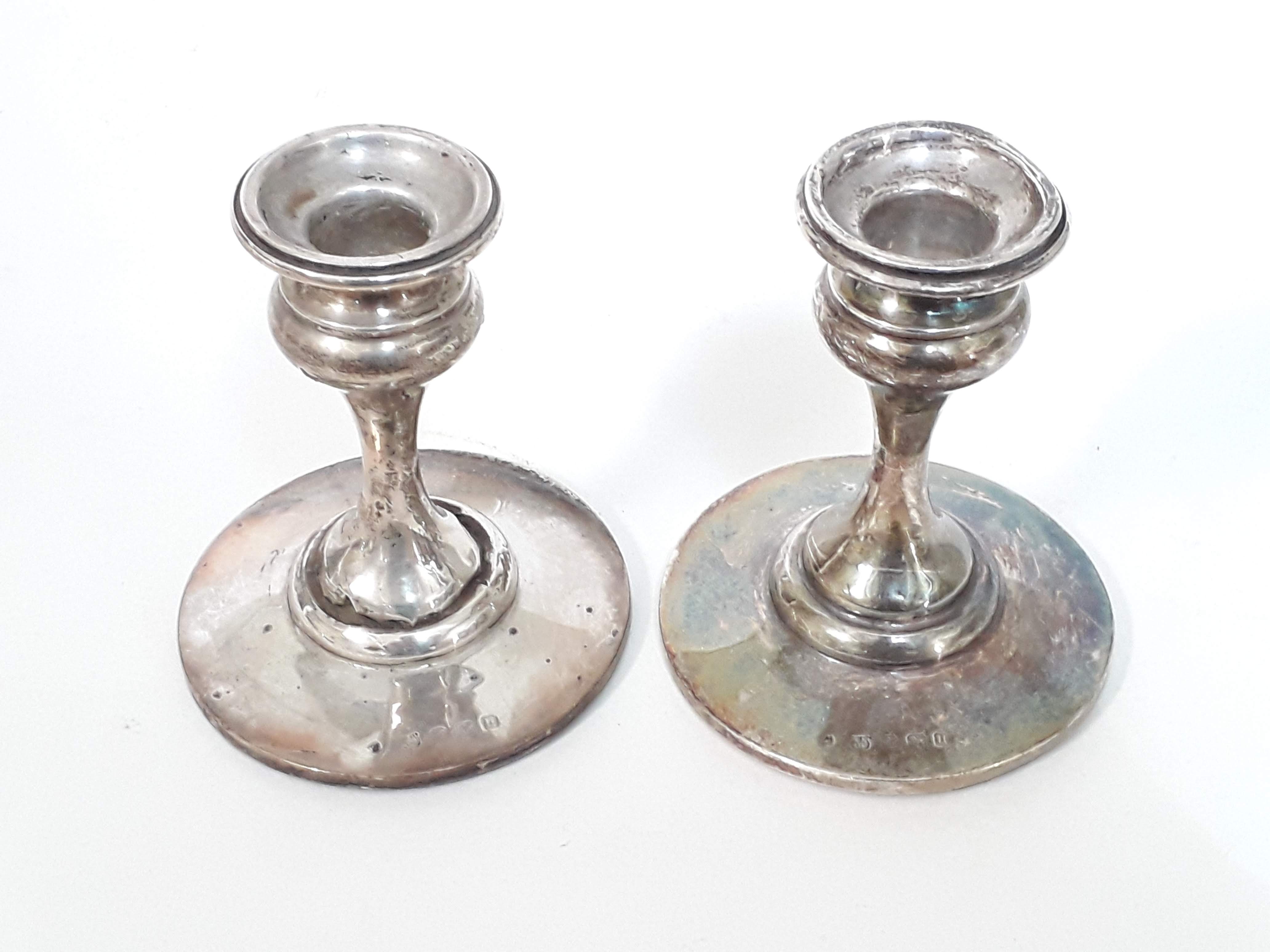 A pair of Art Nouveau style hallmarked silver candle sticks, height 10cm, as found.