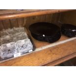 Glass dishes on a plated tray and two sizes of dark glass shell plates