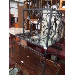 A wrought metal and glass telephone seat.