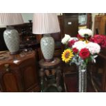 A pair of modern pottery table lamps and a ribbed vase with artificial flowers.