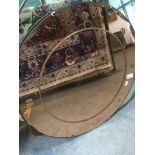 An Art Deco round amber glass bevelled edge mirror, 61cm diameter