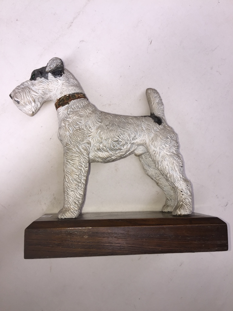 A cold painted spelter figure modelled as a terrier on wooden plinth, length 23cm.