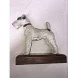 A cold painted spelter figure modelled as a terrier on wooden plinth, length 23cm.