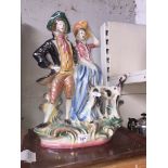 A lustre ware figure in the form of a man and a woman with a dog