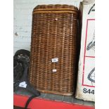A wicker clothes basket with lid.