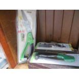A garden saw, secateur, and a folding saw, all unused and in original packages