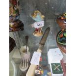 A small Nymphenburg porcelain figure and a knife and fork
