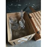 A box containing a very large decanter, another decanter, and a water jug