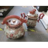 Two large repro Chinese lidded pots, each on three legs, one with over top handle in the form of a