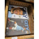 A woven basket containing Manchester City football programmes