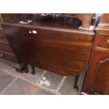 An oak drop leaf table on tapered legs and pad feet