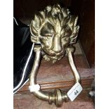 A brass door knocker in the shape of a lions head