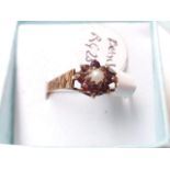 A hallmarked 9ct gold ring with garnets and central pearl
