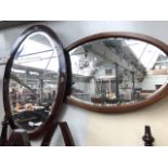 An inlaid oval mirror and another.