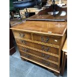 A reproduction yew wood chest of drawers