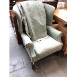 A reproduction wing back armchair with matching curtains