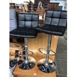 A pair of chrome based swivel kitchen bar stools