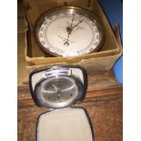 Aneroid circular barometer by Wilson Warden and Co London and a portable alarm clock