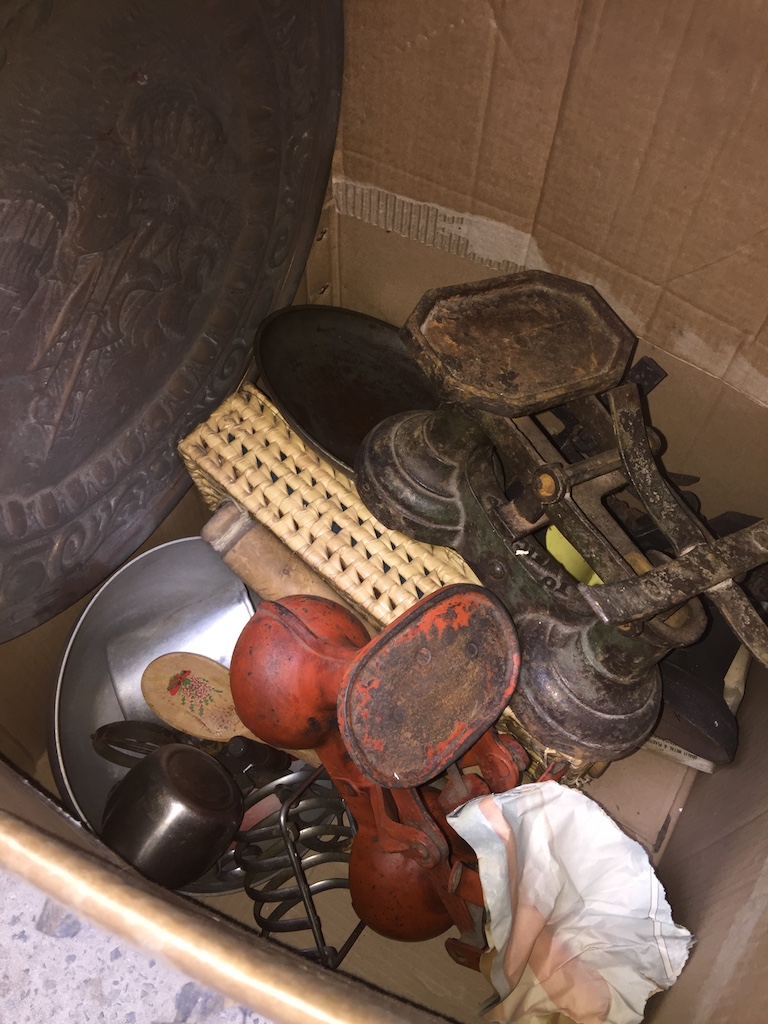 A box of metalware to include 3 sets of kitchen scales, 2 large brass chargers, etc.