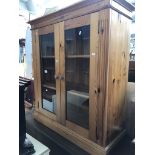 A pine glazed two door bookcase