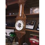 A carved oak cased barometer