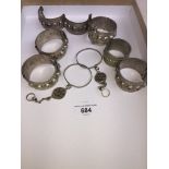 A tray containing 7 small hinged bracelets and a pair of earrings/pendants