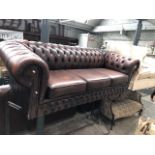 A brown leather Chesterfield three seater settee